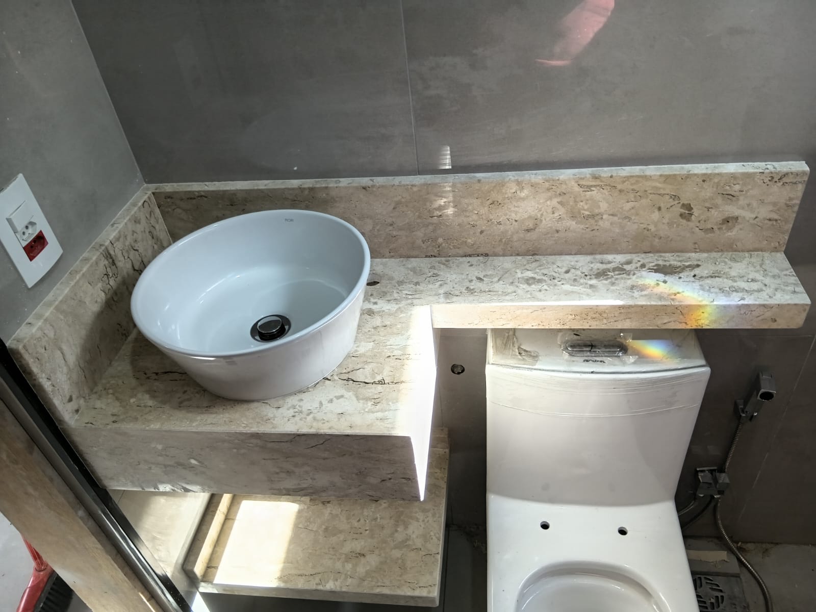 Bancada de lavabo em mármore travertino com cuba de apoio redonda