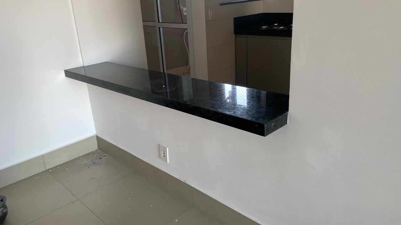 Balcão passa-pratos em granito preto entre cozinha e sala