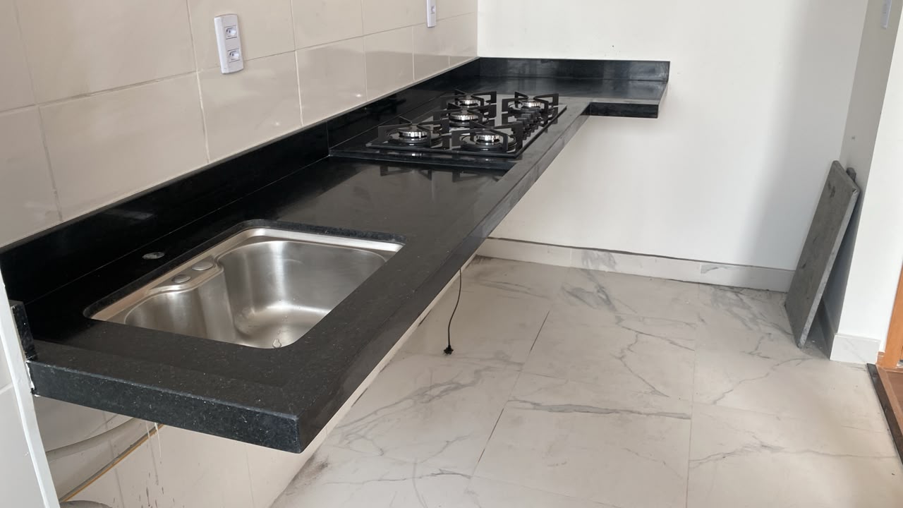Bancada de cozinha em granito preto com cooktop e cuba inox