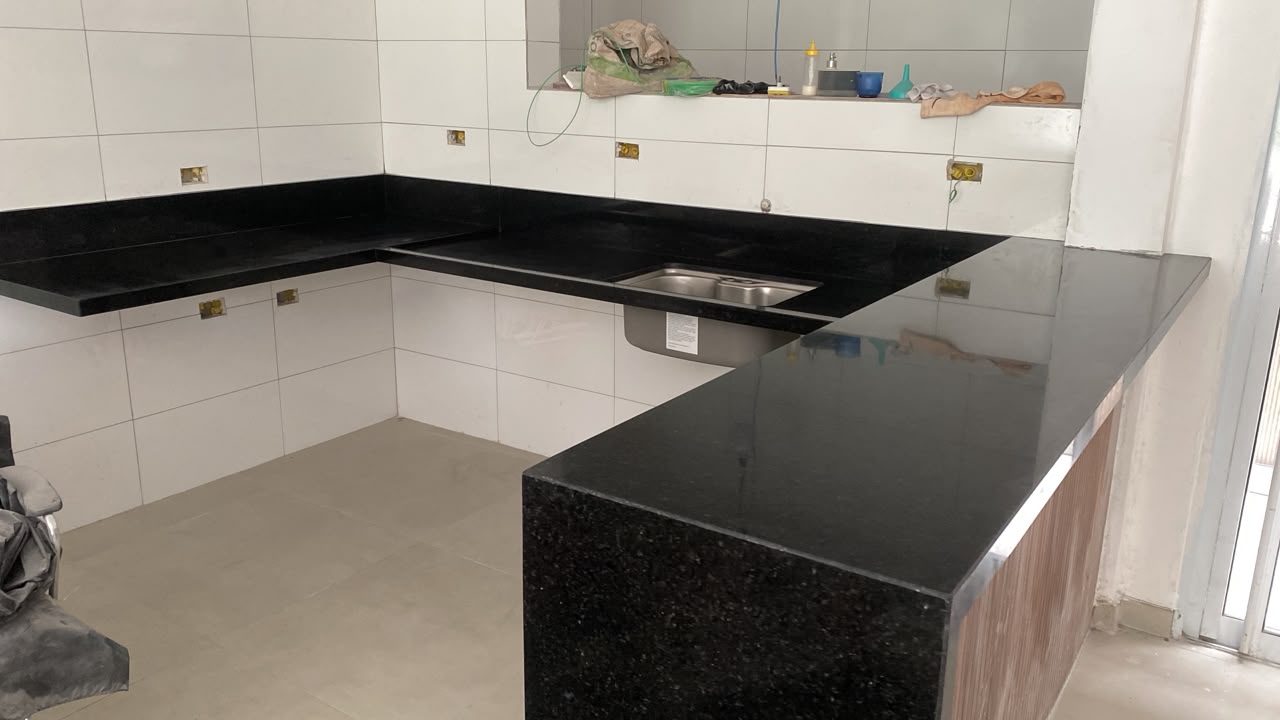 Cozinha em U com bancadas e balcão em granito preto polido