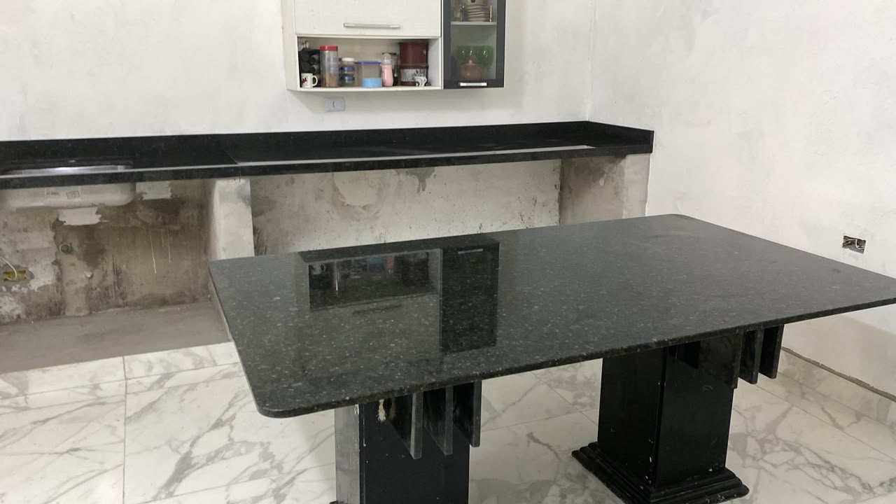 Mesa de jantar em granito preto com pés esculpidos em pedra